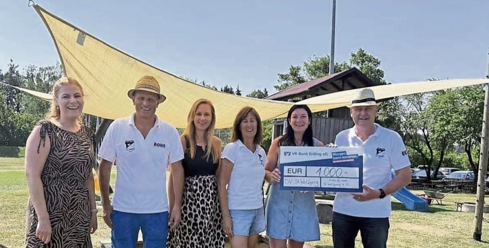Vertreterinnen von Kids and More und vom TSV St. Wolfgang mit einem Spendenscheck über 1.000 Euro unter dem neuen Sonnensegel