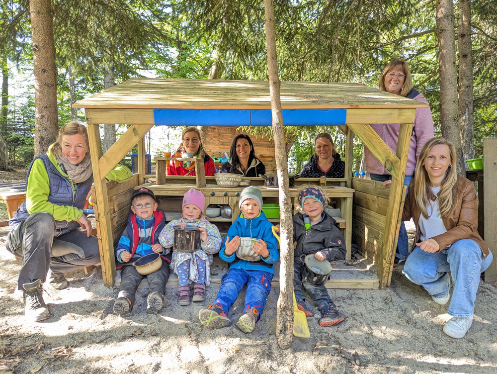 Kinder und Erzieherinnen vor der neuen Matschküche im Waldkindergarten Armstorf